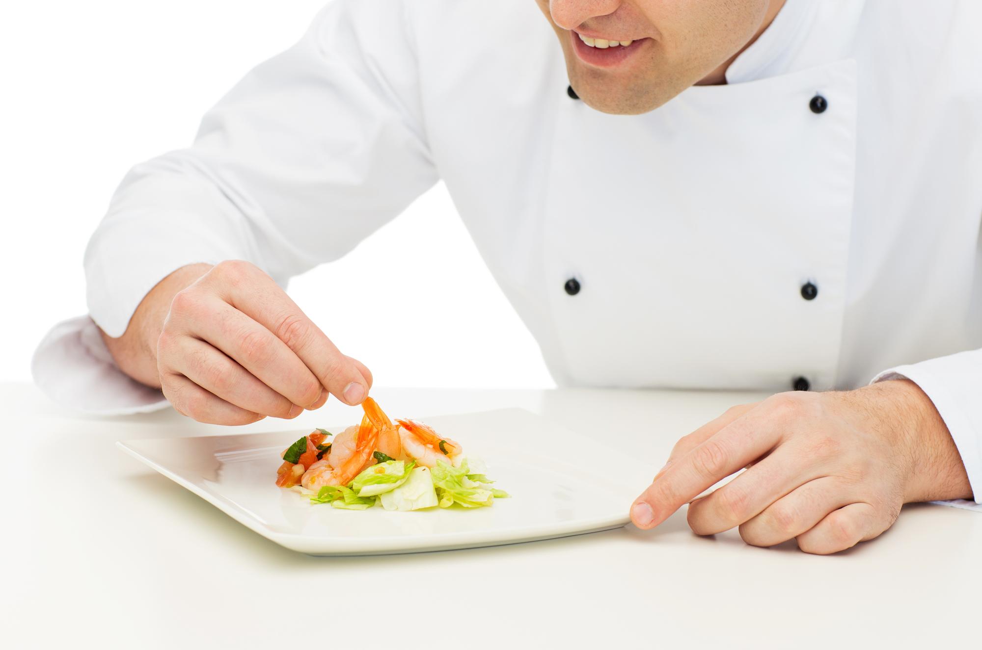 Chef che affetta con cura un ingrediente in cucina professionale